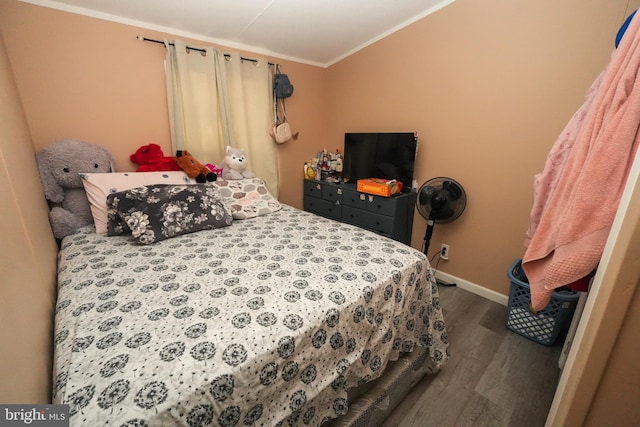 bedroom with dark hardwood / wood-style flooring and crown molding