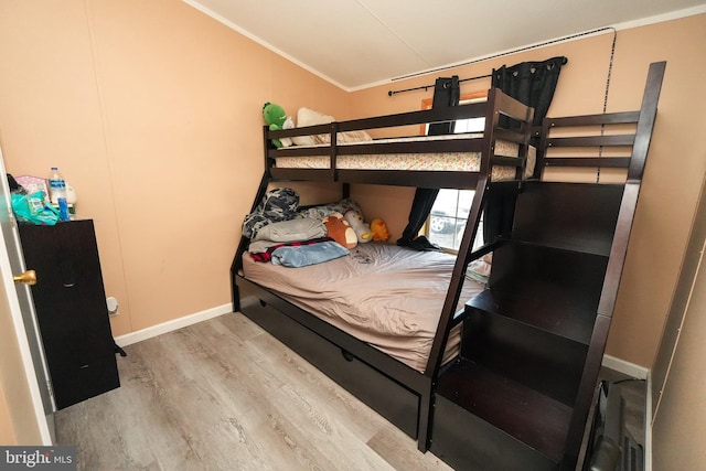 bedroom with crown molding and light hardwood / wood-style flooring