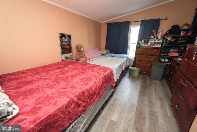 bedroom featuring light wood-type flooring and vaulted ceiling