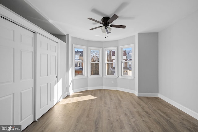 unfurnished bedroom with a closet, ceiling fan, and hardwood / wood-style flooring