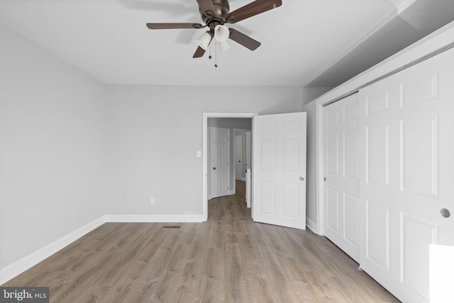 unfurnished bedroom with ceiling fan, light hardwood / wood-style floors, and a closet