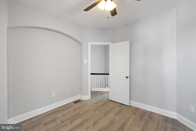 spare room with ceiling fan and wood-type flooring