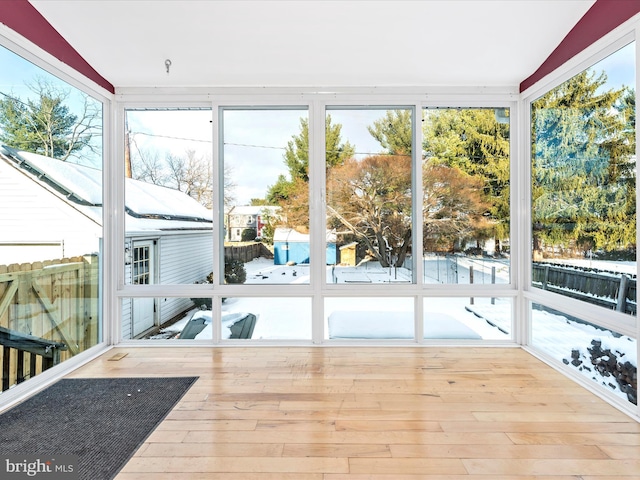 sunroom with a healthy amount of sunlight and vaulted ceiling