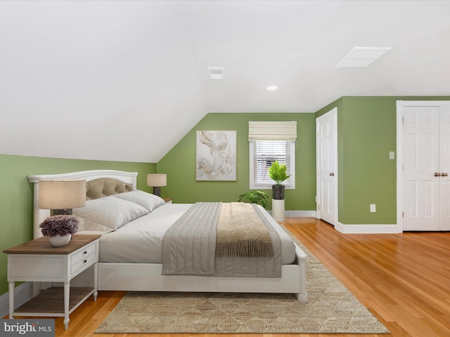 bedroom featuring hardwood / wood-style flooring and lofted ceiling