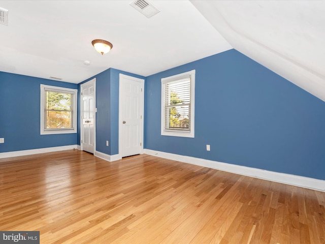 bonus room with a healthy amount of sunlight, light hardwood / wood-style flooring, and lofted ceiling