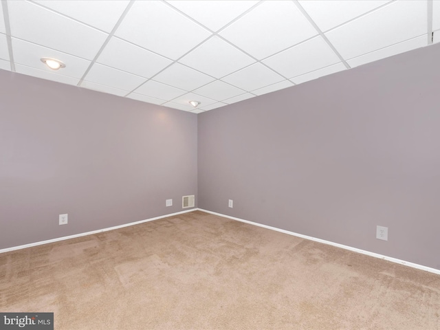 empty room with carpet floors and a paneled ceiling