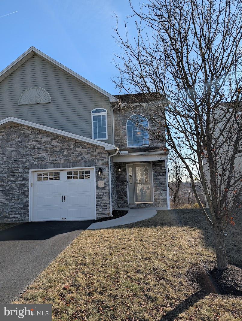 view of property featuring a front lawn and a garage