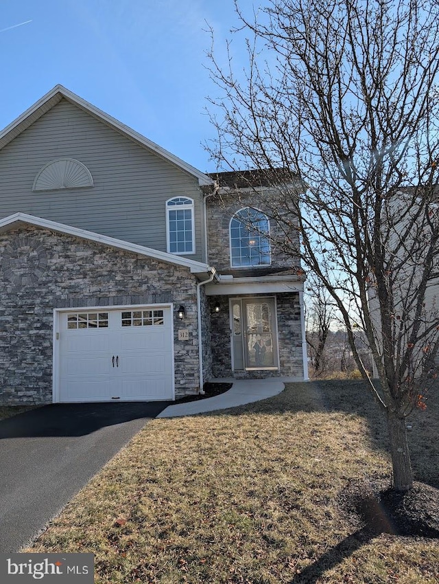 view of property featuring a front lawn and a garage