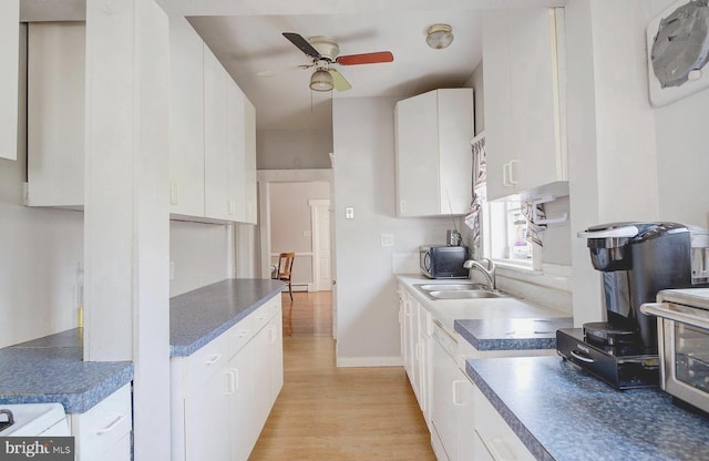 kitchen featuring light hardwood / wood-style flooring, white cabinetry, ceiling fan, and sink