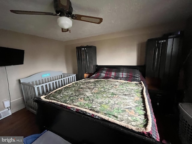 bedroom with ceiling fan and dark wood-type flooring