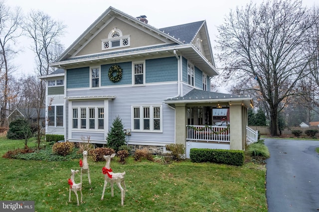 view of front of property with a porch and a front yard