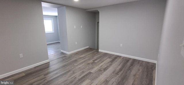 unfurnished room with dark wood-type flooring