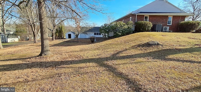 exterior space with central air condition unit, an outbuilding, a front yard, and a garage