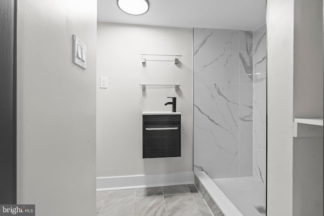 bathroom featuring a tile shower and vanity