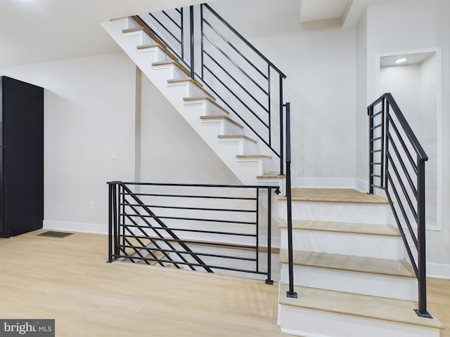 stairway with hardwood / wood-style flooring