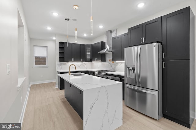 kitchen with light stone countertops, stainless steel appliances, sink, a center island with sink, and hanging light fixtures