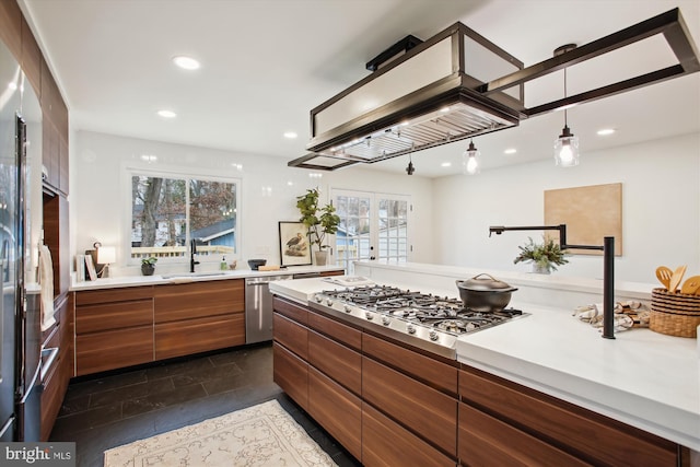 kitchen featuring decorative light fixtures, stainless steel appliances, french doors, and sink