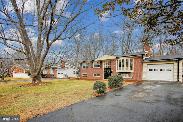 split foyer home with a garage and a front lawn