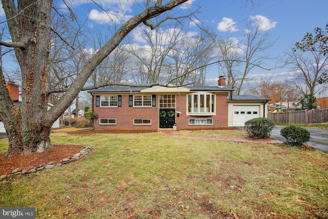 raised ranch with a front yard and a garage