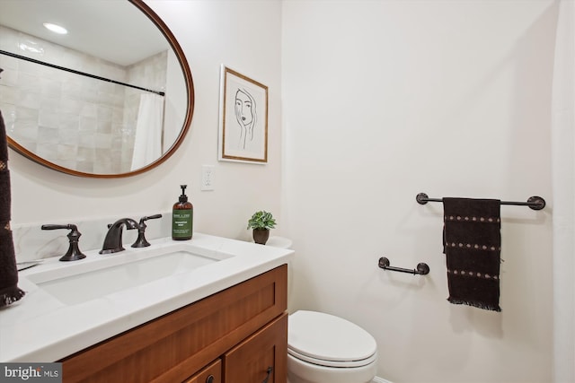 bathroom with walk in shower, vanity, and toilet