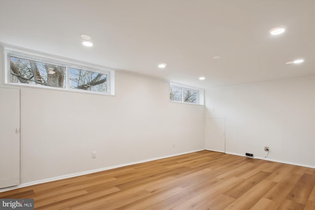 basement featuring a wealth of natural light and light hardwood / wood-style flooring