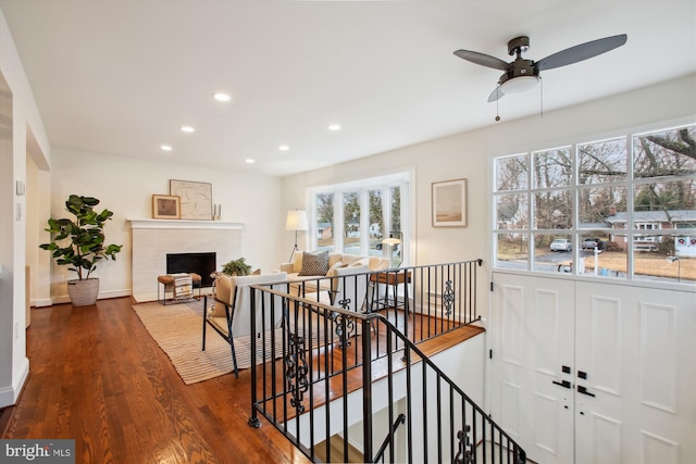 stairs featuring ceiling fan and hardwood / wood-style flooring