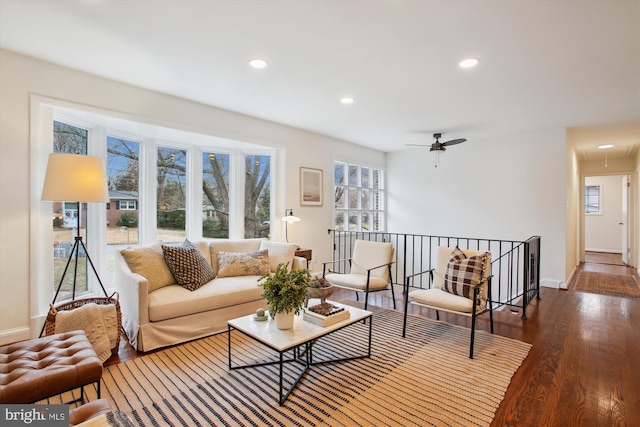 living room featuring ceiling fan and dark hardwood / wood-style floors