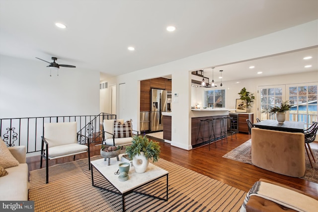 living room featuring ceiling fan, dark wood-type flooring, and beverage cooler