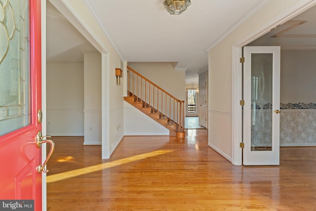 entryway with hardwood / wood-style floors and crown molding