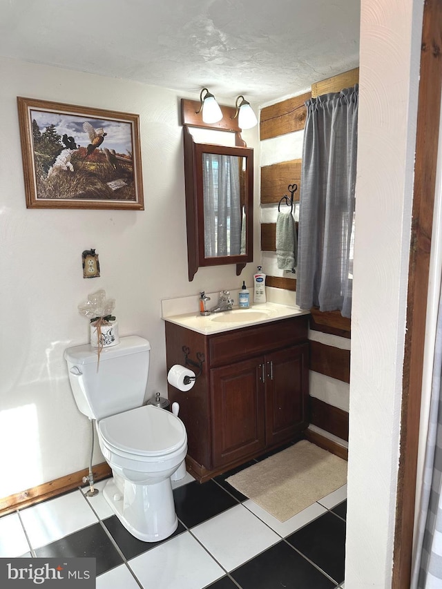 bathroom featuring tile patterned flooring, vanity, and toilet