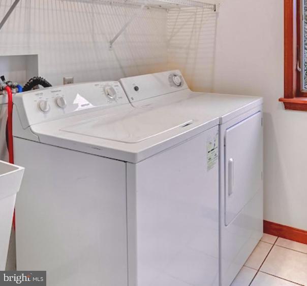 washroom featuring washing machine and dryer and light tile patterned floors