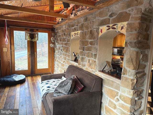 unfurnished living room featuring beam ceiling, hardwood / wood-style flooring, french doors, and wooden ceiling