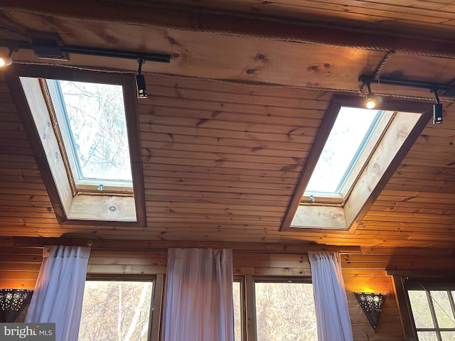 interior details with wooden ceiling, wooden walls, and a skylight