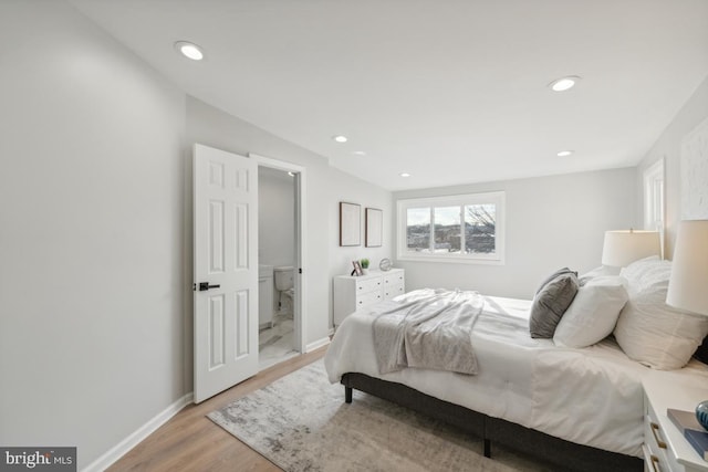 bedroom featuring ensuite bath and light wood-type flooring