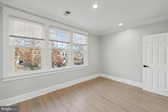 spare room featuring light hardwood / wood-style flooring and ornamental molding