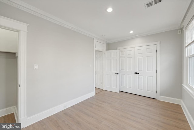 unfurnished bedroom featuring light hardwood / wood-style flooring, a closet, and crown molding