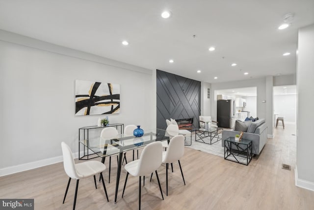 dining area with light hardwood / wood-style floors and crown molding