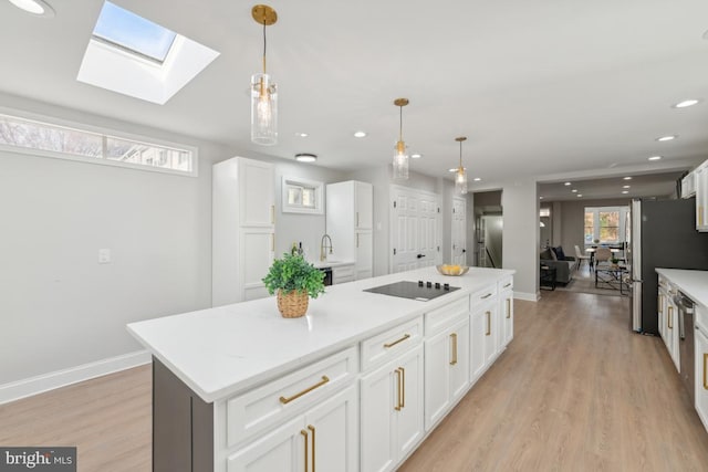 kitchen featuring pendant lighting, a center island, stainless steel fridge, and white cabinetry