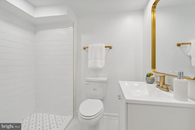 bathroom featuring vanity, toilet, and tiled shower