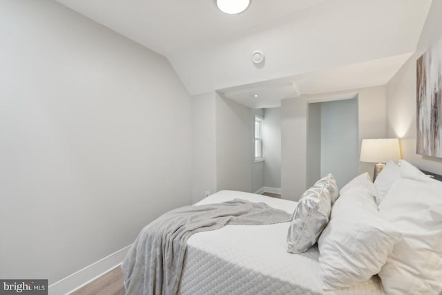 bedroom with light hardwood / wood-style flooring and lofted ceiling