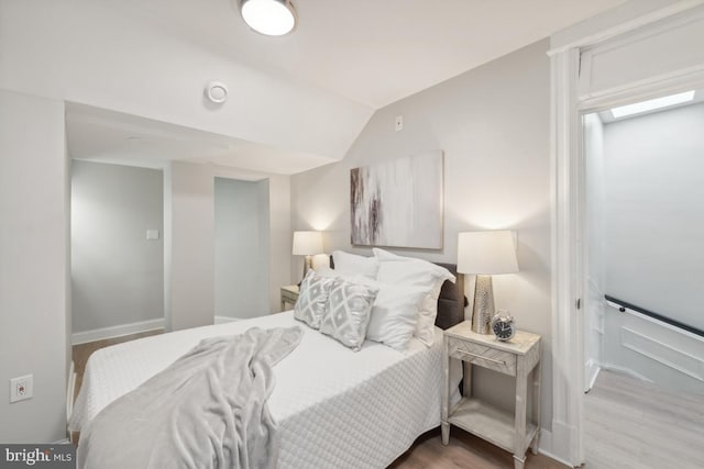 bedroom with hardwood / wood-style flooring and vaulted ceiling