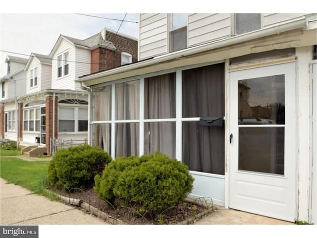 view of property exterior with a sunroom