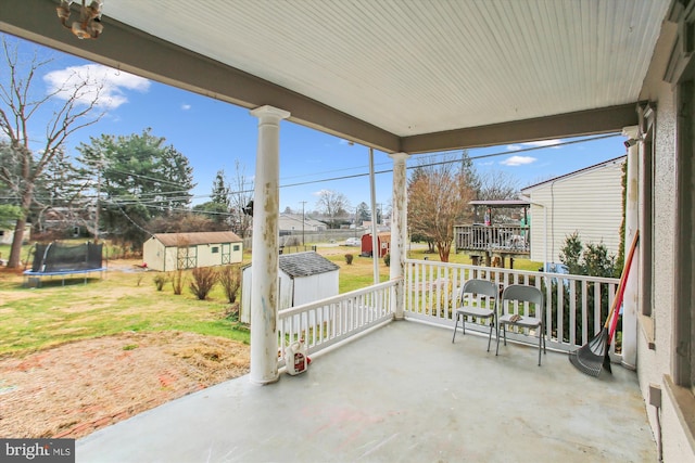 view of patio with covered porch, a trampoline, and a storage shed