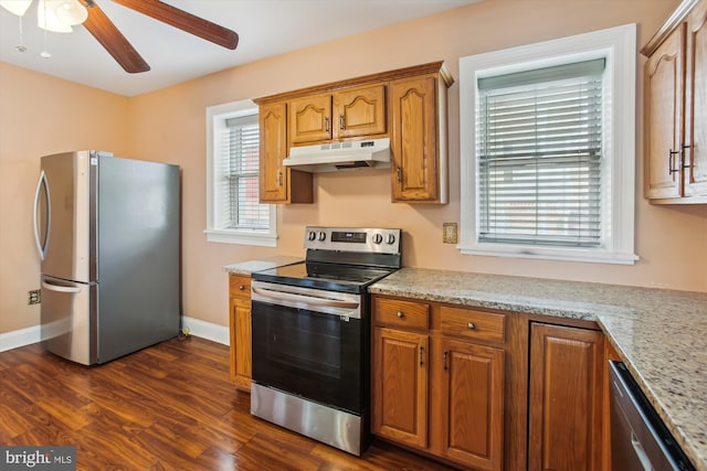 kitchen with light stone countertops, stainless steel appliances, dark hardwood / wood-style floors, and ceiling fan