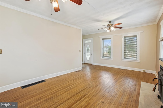 unfurnished living room featuring hardwood / wood-style flooring and crown molding