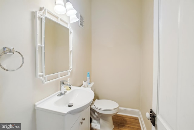 bathroom featuring wood-type flooring, vanity, and toilet