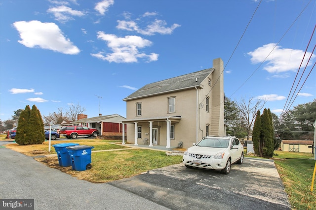 view of property featuring a porch and a front lawn