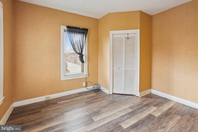 unfurnished bedroom with hardwood / wood-style flooring and a closet