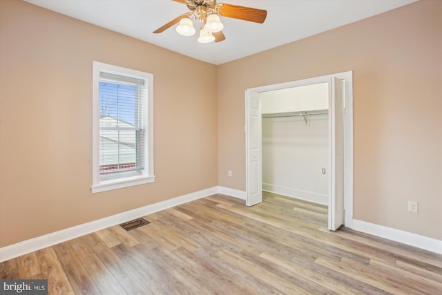 unfurnished bedroom with a closet, light hardwood / wood-style flooring, and ceiling fan