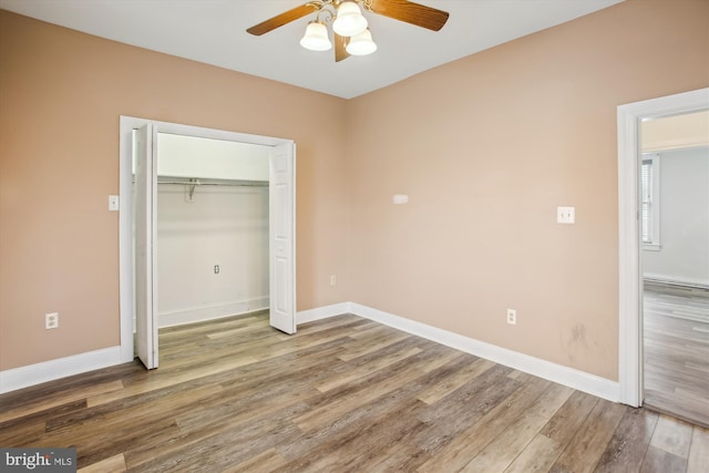 unfurnished bedroom with ceiling fan, a closet, and wood-type flooring